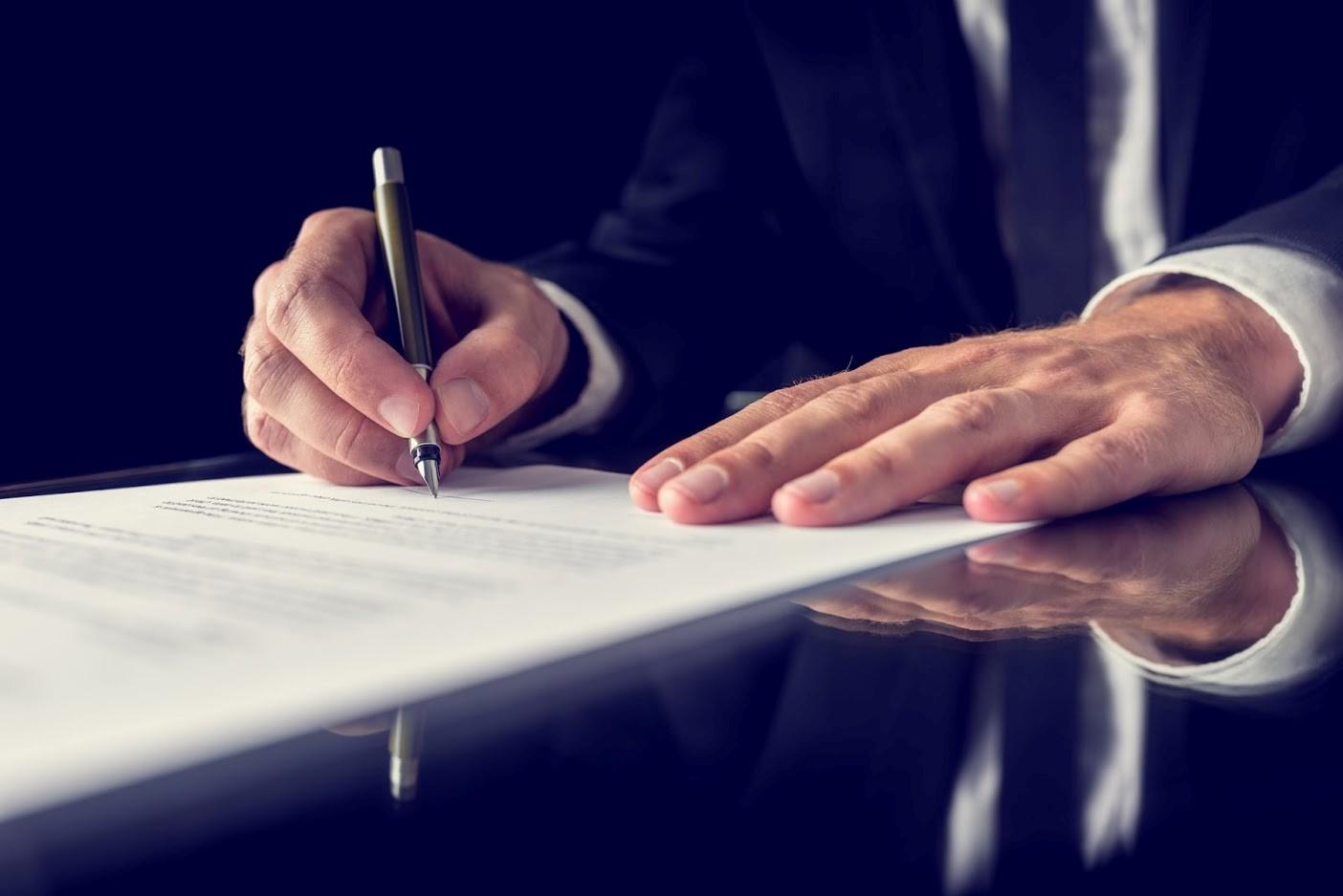 Man Signing A Paper — Waukegan, IL — Daniels, Long & Pinsel, LLC