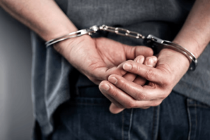 Handcuffed Criminal Man Hands Close Up — Waukegan, IL — Daniels, Long & Pinsel, LLC